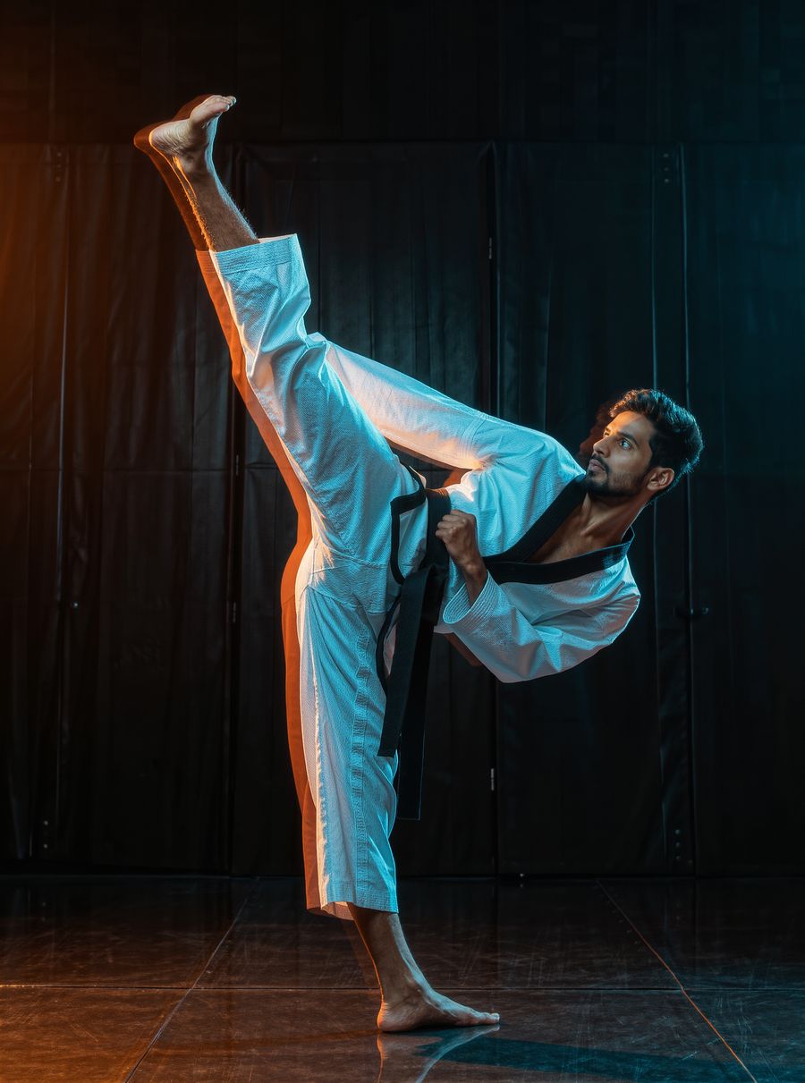 Taekwondo athlete in a white dobok throwing a high kick